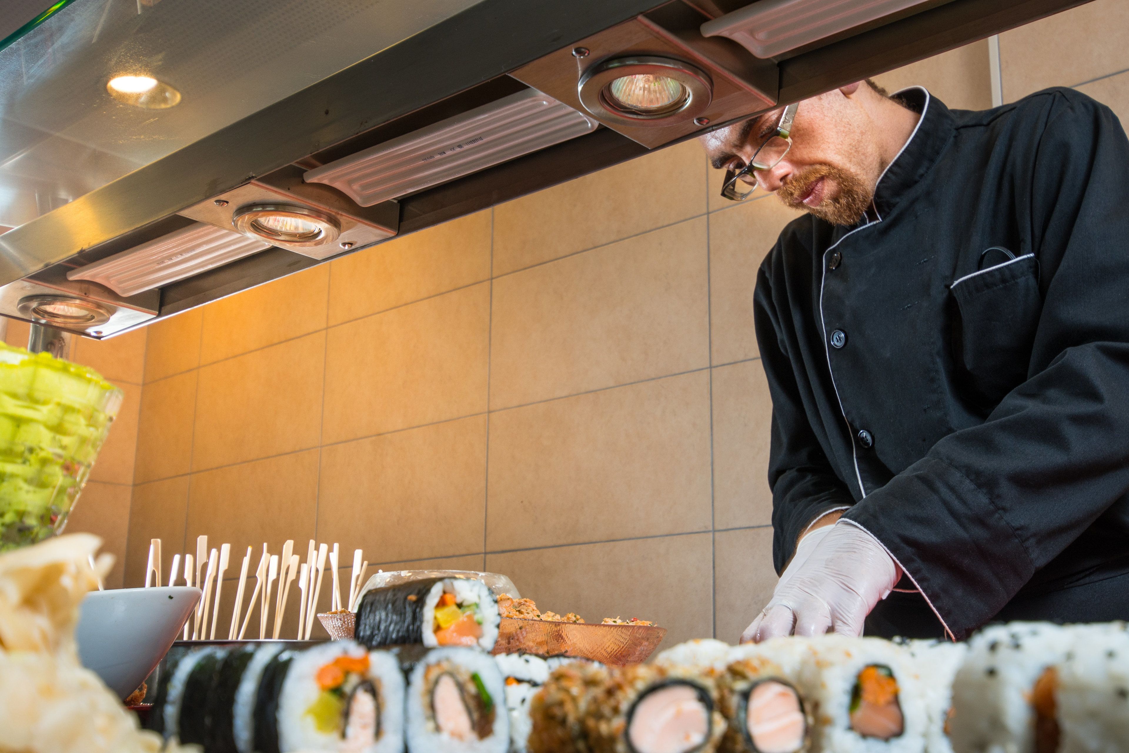 A sushi bar with various types of sushi displayed on a counter.