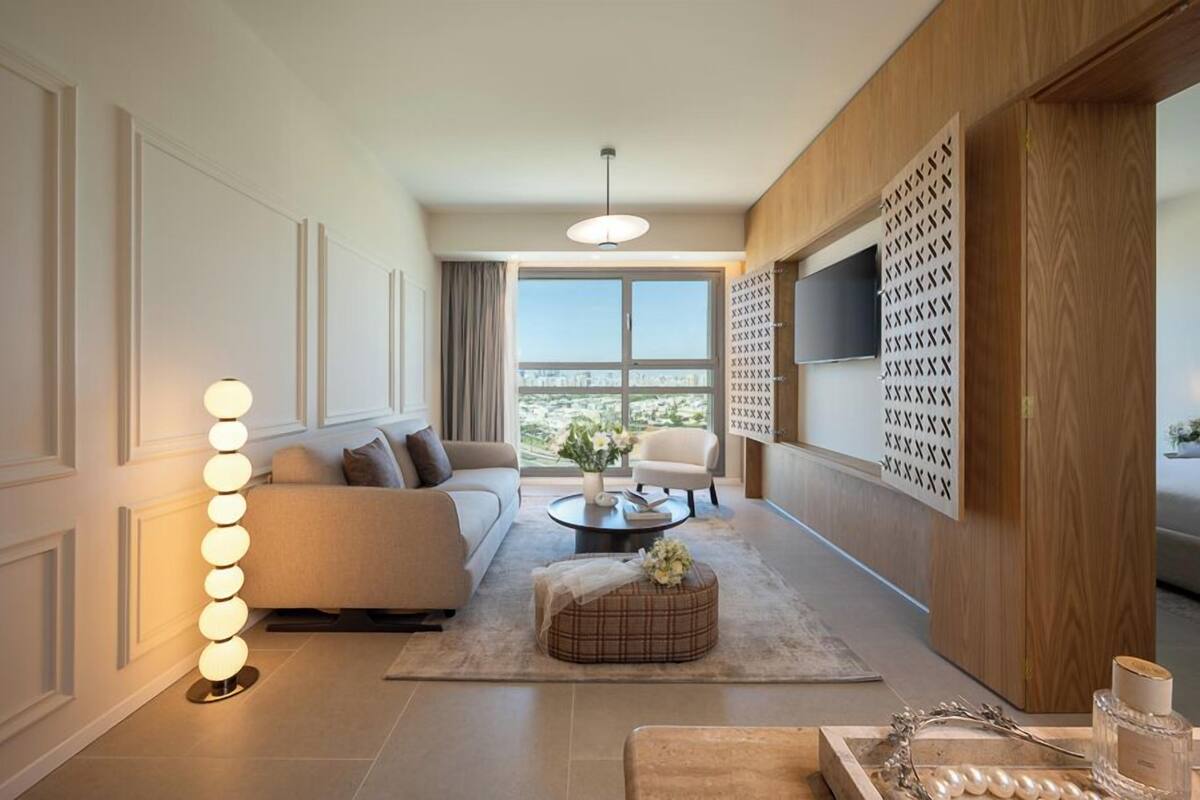 Una sala de estar moderna con sofá, sillón, mesa de centro y adornos.