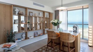 A modern kitchen with a bar area, large windows, and a view of the sea. - Leonardo Plaza Ashdod (Ashdod)