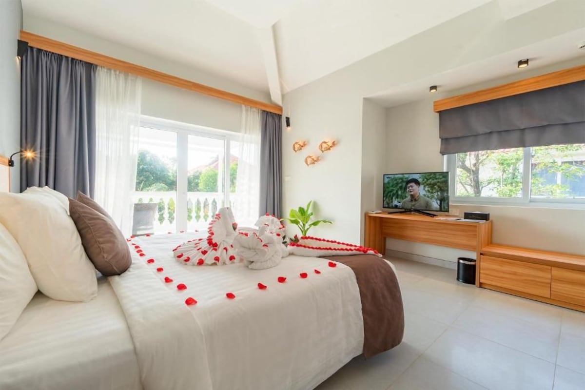 Une chambre d’hôtel avec un lit, un bureau et une télévision.