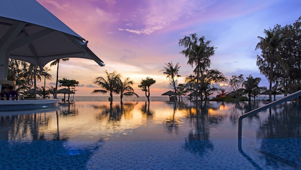 A pool with a tiled floor and palm trees in the background. - Mercury Phu Quoc Resort & Villas - Free Airport Transfer (Phu Quoc)