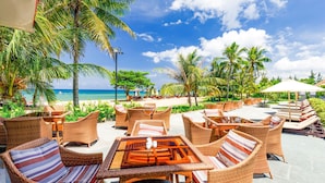 An outdoor seating area with wicker furniture and a view of the ocean. - Mercury Phu Quoc Resort & Villas - Free Airport Transfer (Phu Quoc)