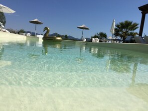 室外游泳池，提供泳池遮陽傘和日光浴躺椅
