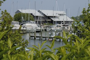A marina with boats docked at wooden piers, surrounded by greenery.