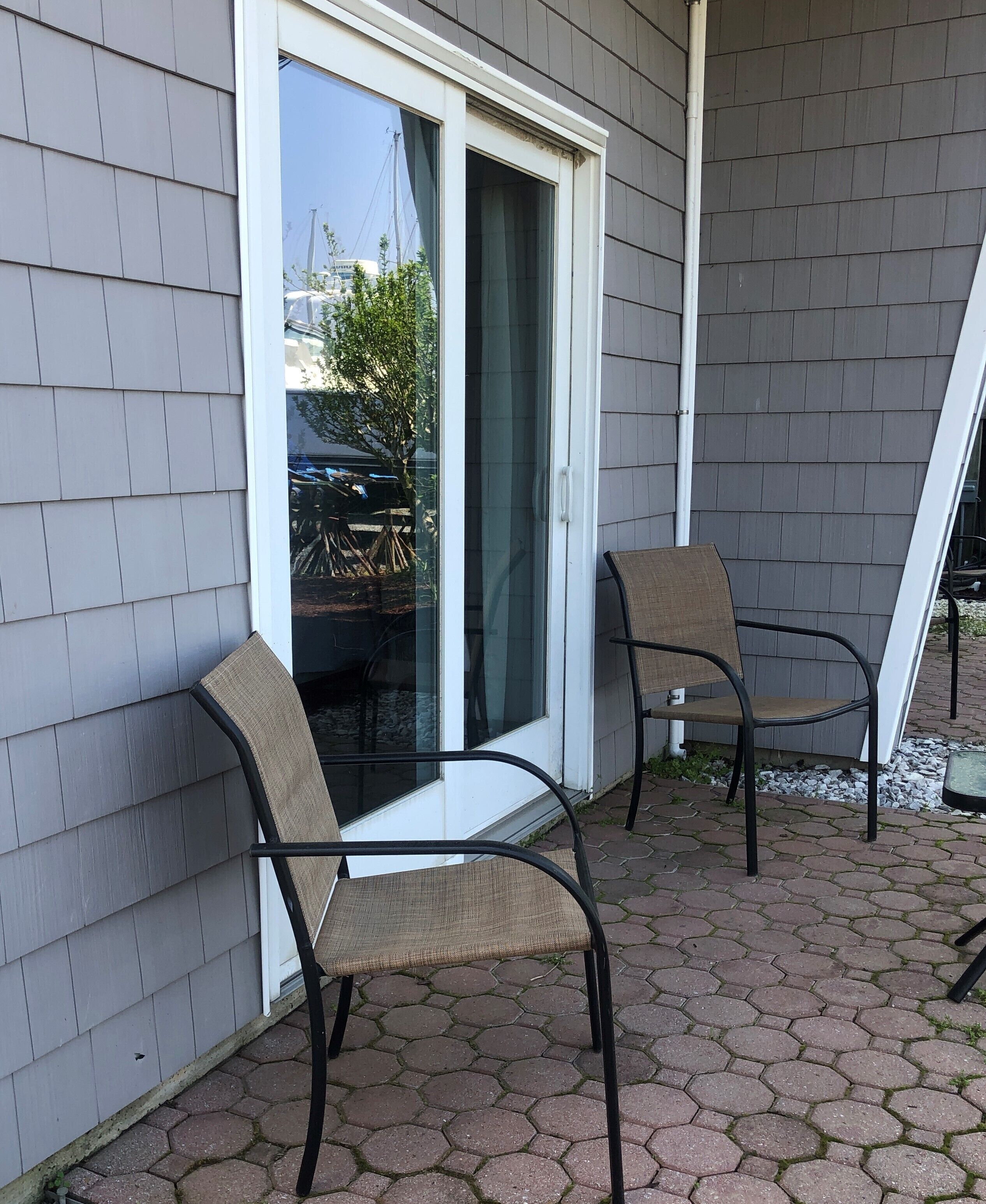 A patio with two chairs and a sliding glass door.