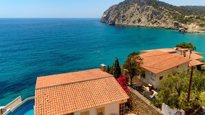 A coastal view with a mountain, clear blue sea, and buildings with red-tiled roofs. - Aparthotel Ola Blanca (Finestrat)