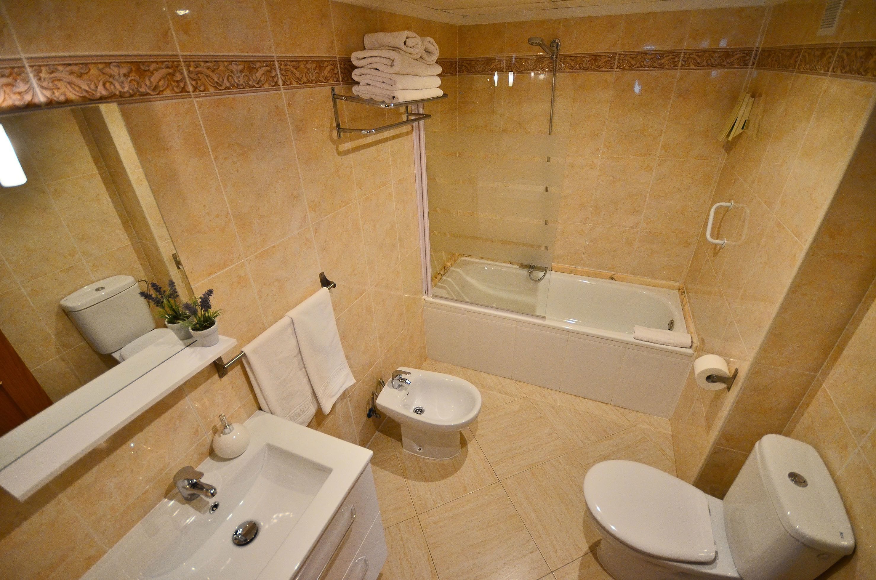 A bathroom with a bathtub, toilet, bidet, and sink.