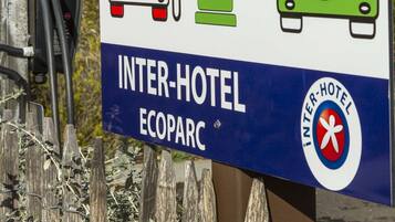 Señal de un Inter-Hotel Ecoparc con símbolos que indican una estación de carga y un sol.