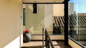 Een modern hotelinterieur met een glazen wand met uitzicht op het dak.