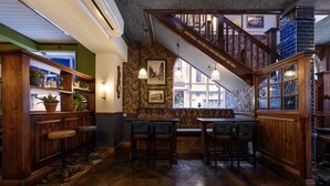 A bar area with wooden furniture, a staircase, and a view of the street. - The Abel Heywood (Manchester)