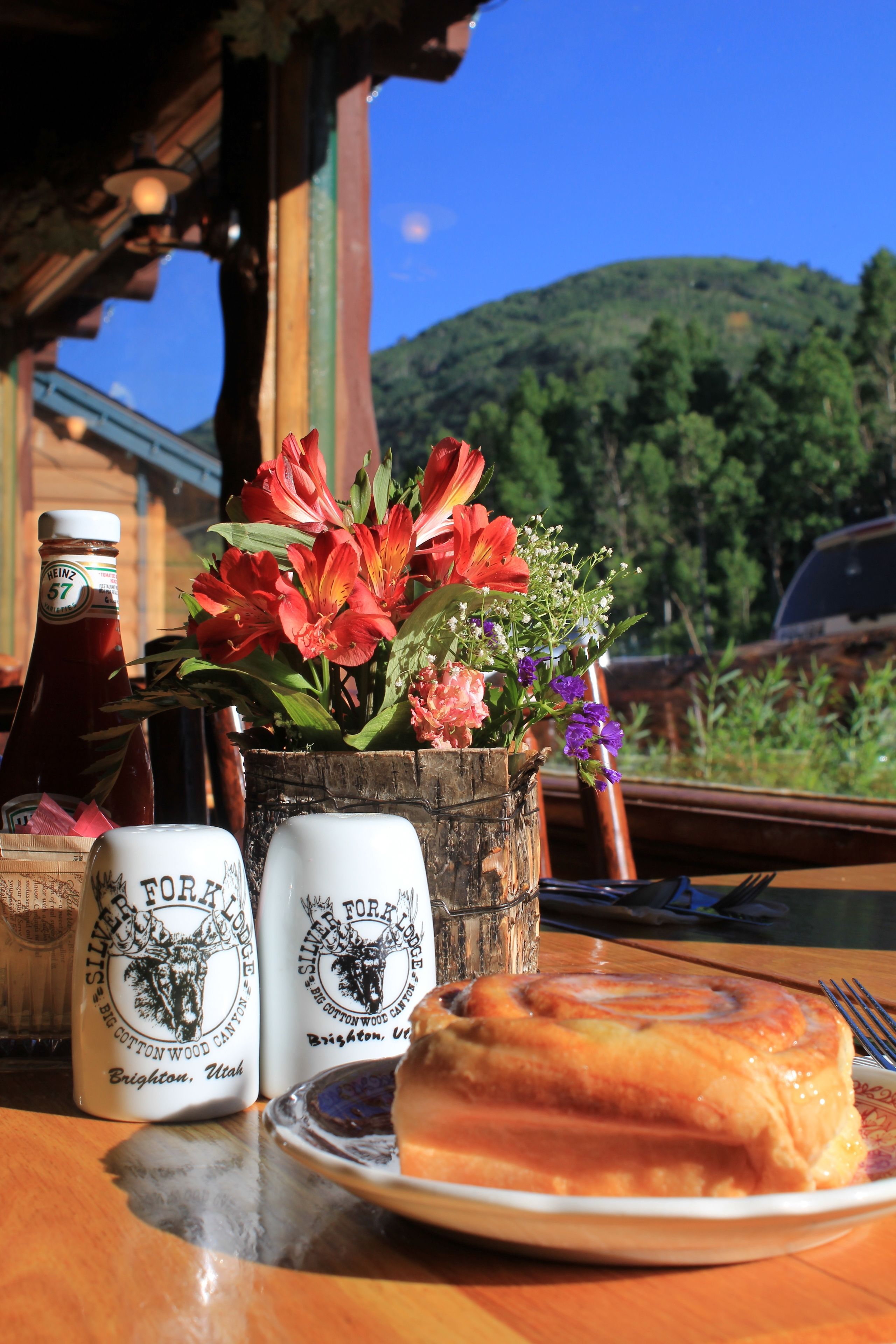 Ein Tisch mit Essen, einer Ketchupflasche und zwei Salz- und Pfefferstreuern.