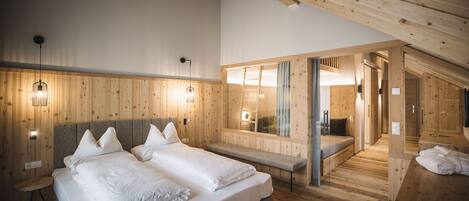 Un dormitorio moderno con una cama grande, un banco y un vestidor.