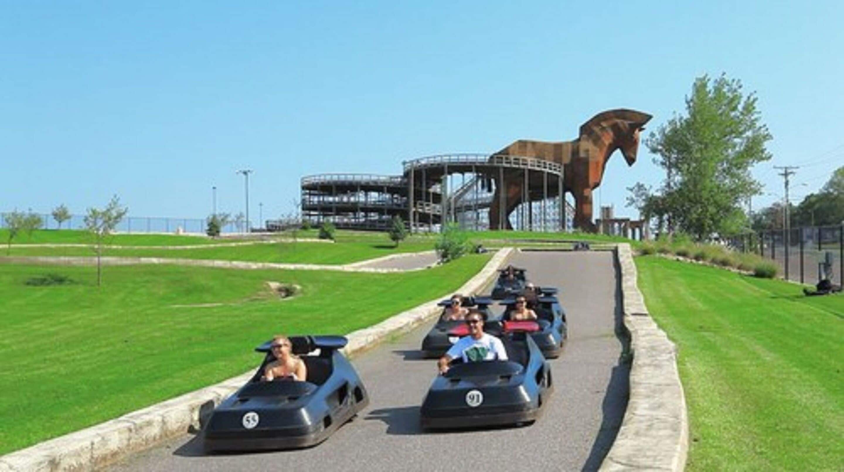 Une piste de karting avec une grande statue de cheval en arrière-plan.