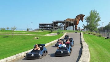 A go-kart track with a large horse statue in the background.