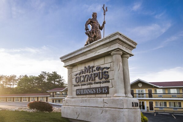 A statue on a pedestal with a sign indicating "Mt. Olympus" and "Buildings 13-15".