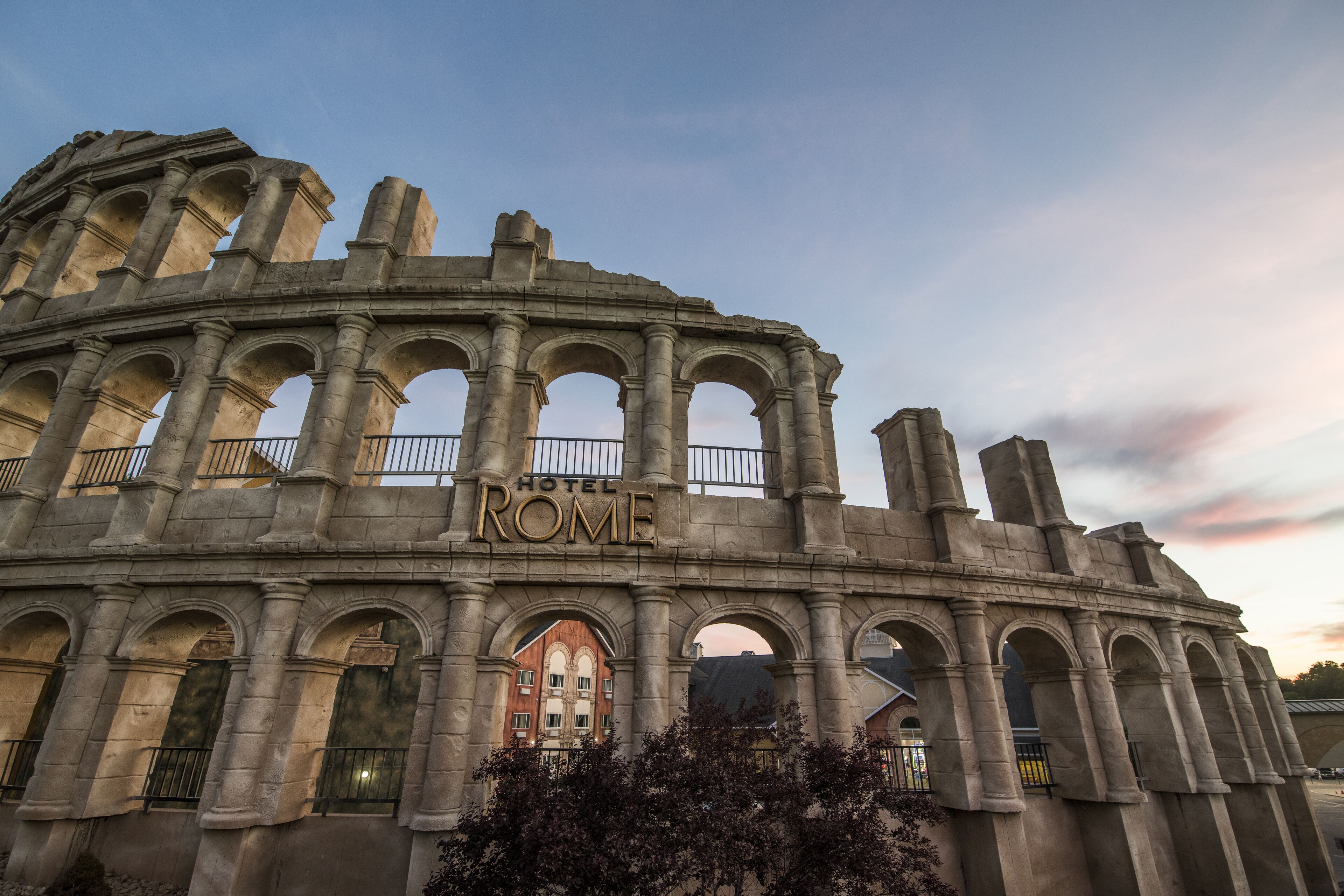 A historic stone structure with the inscription "HOTEL ROME" and multiple arches.
