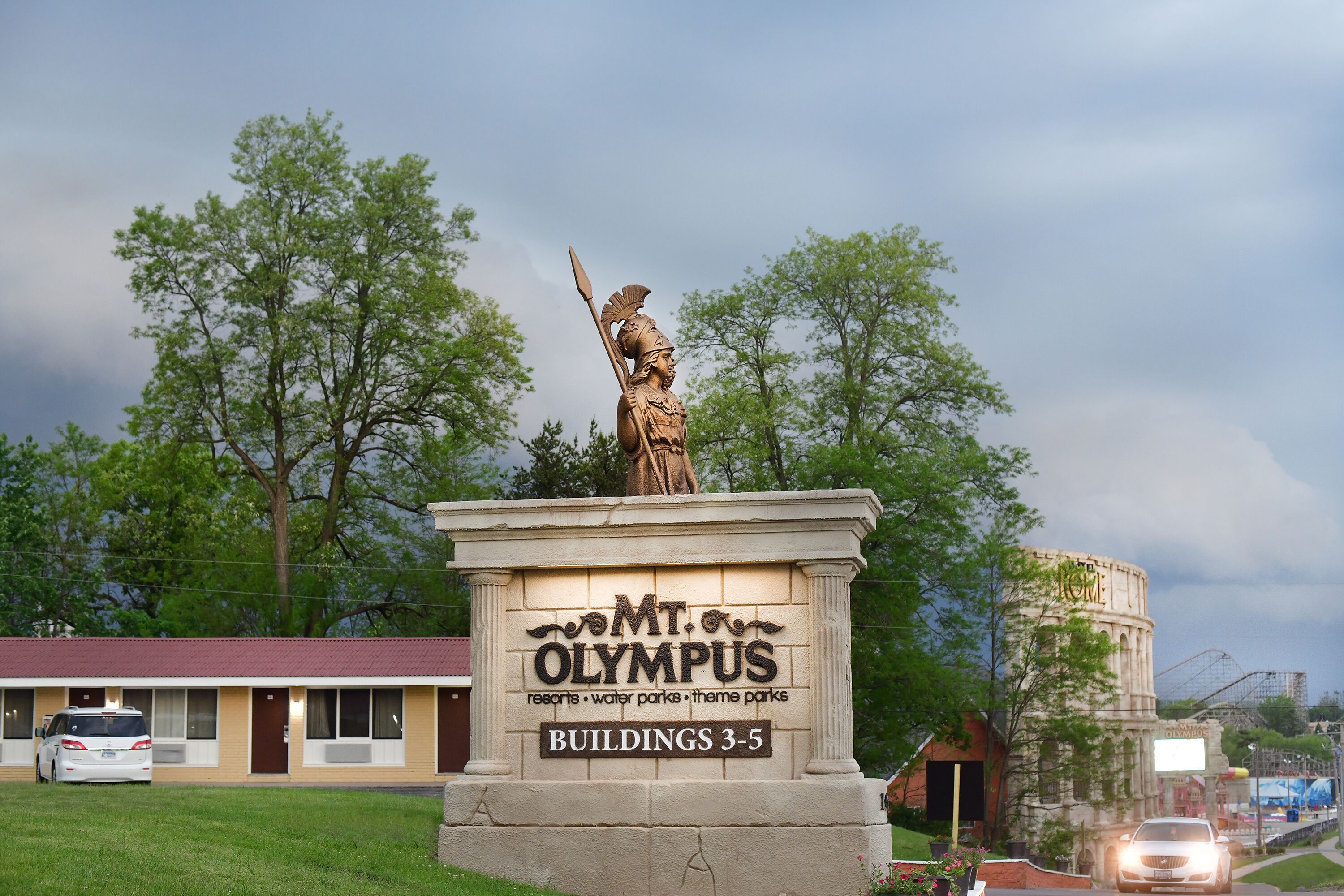Señal de Monte Olimpo con una estatua de una figura sosteniendo una lanza, y referencias a los edificios 3-5.