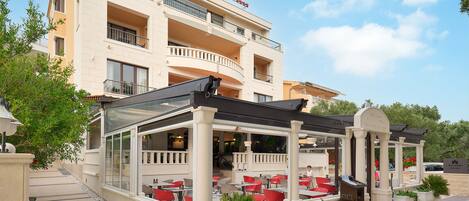 Un hotel con asientos al aire libre, un patio cubierto y un letrero que dice "Villa Andrea".