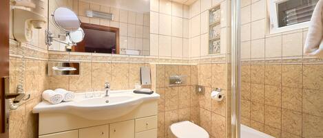 Un baño moderno con lavamanos, inodoro y ducha.
