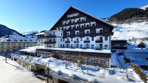 Un hotel grande con varios balcones y una pista de esquí al fondo.