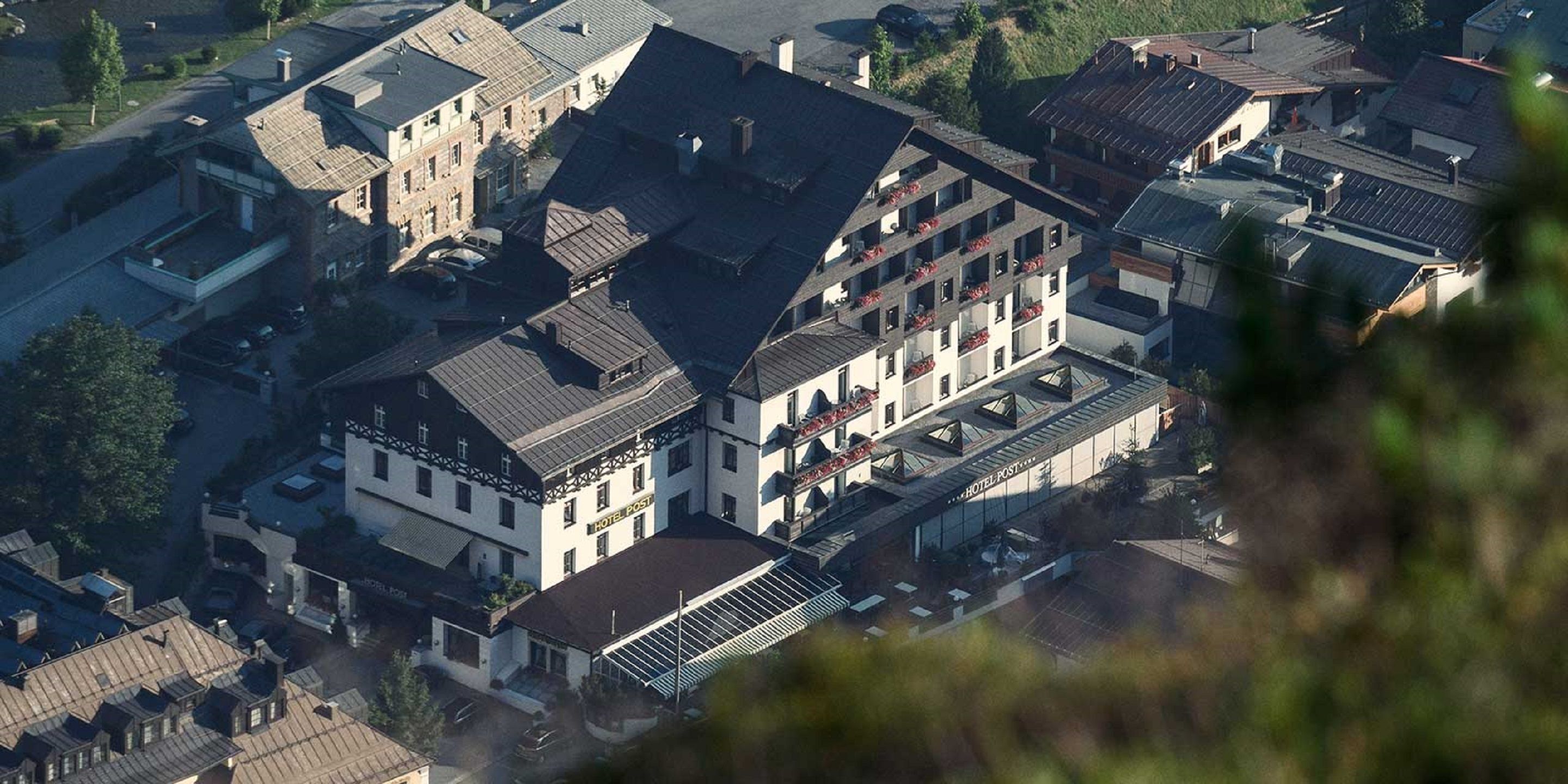 Ein Hotel mit einem zentralen Innenhof, mehreren Etagen und einer Mischung aus traditioneller und moderner Architektur.