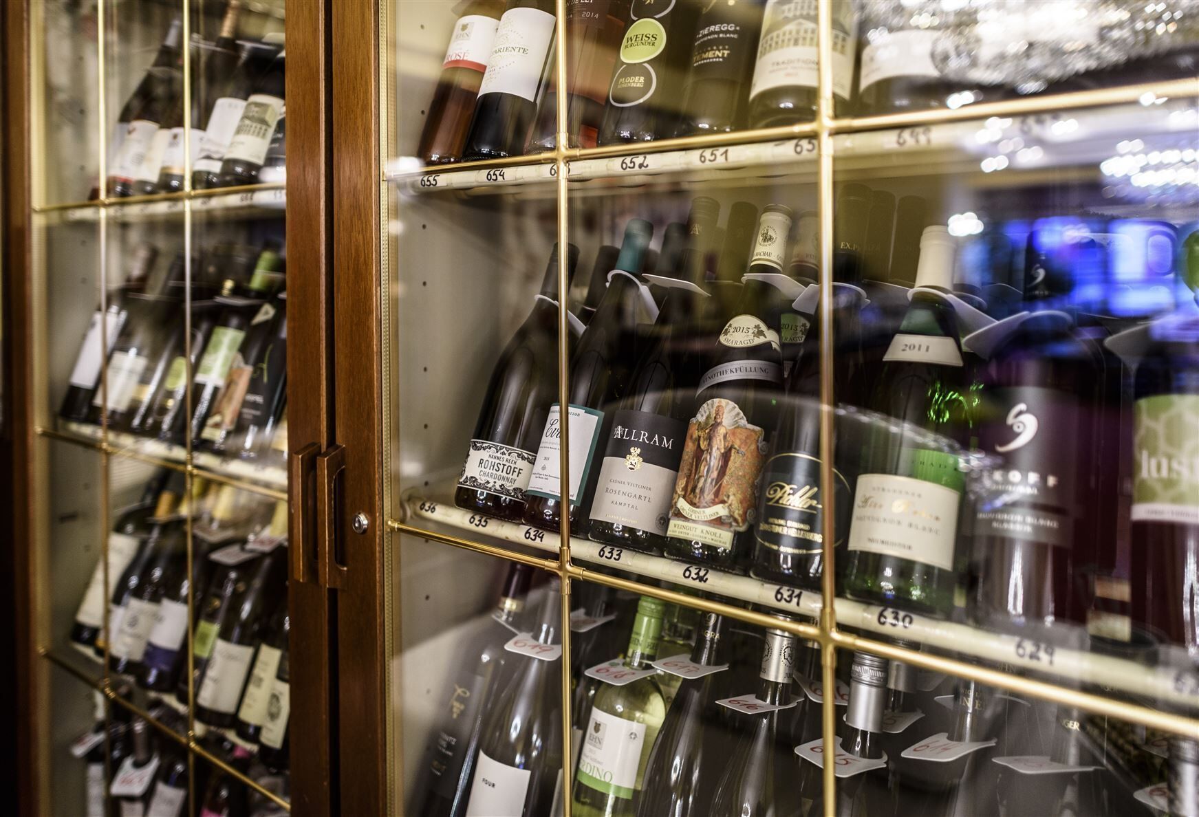 Une cave à vin avec des étagères portant des numéros, où sont rangées différentes bouteilles de vin.