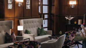 Un área de estar moderna con un sofá, sillones y una mesita.
