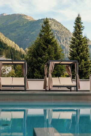 Una piscina techada, una piscina al aire libre de temporada, sombrillas