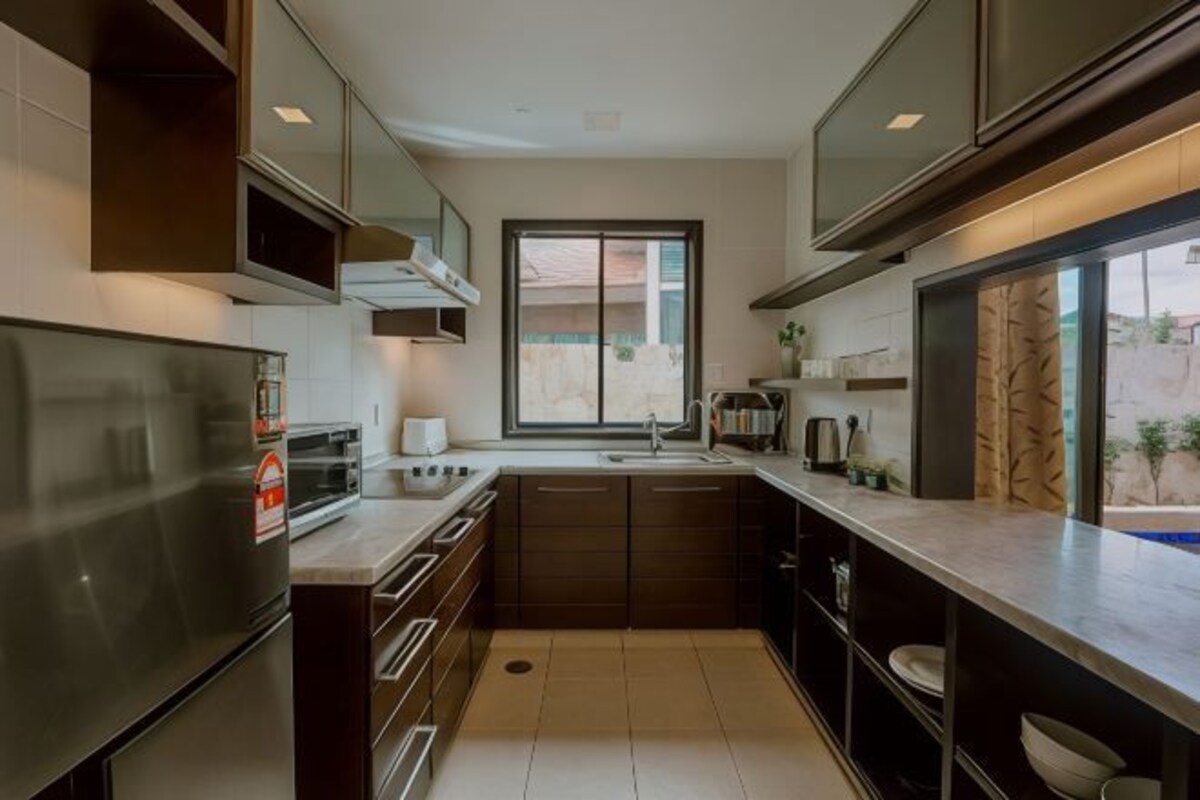 Cocina moderna con electrodomésticos integrados, ventana y vistas al exterior.