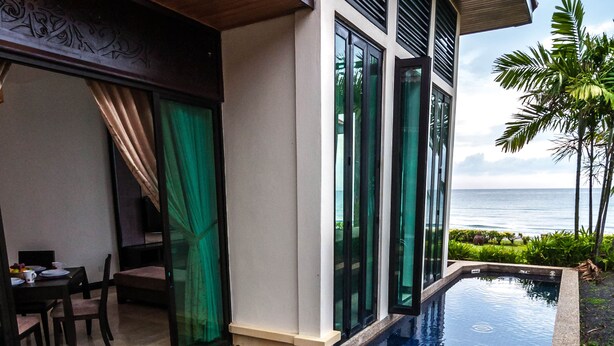 A modern hotel with a swimming pool, large windows, and a view of the ocean. - Borneo Beach Villa & Suite (Kota Kinabalu)