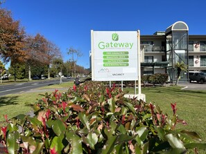 A sign for Gateway International Motel advertising amenities like free unlimited Wi-Fi, mineral pools, spa pools & baths, and bike & motorbike storage. - Gateway International Motel (Rotorua)