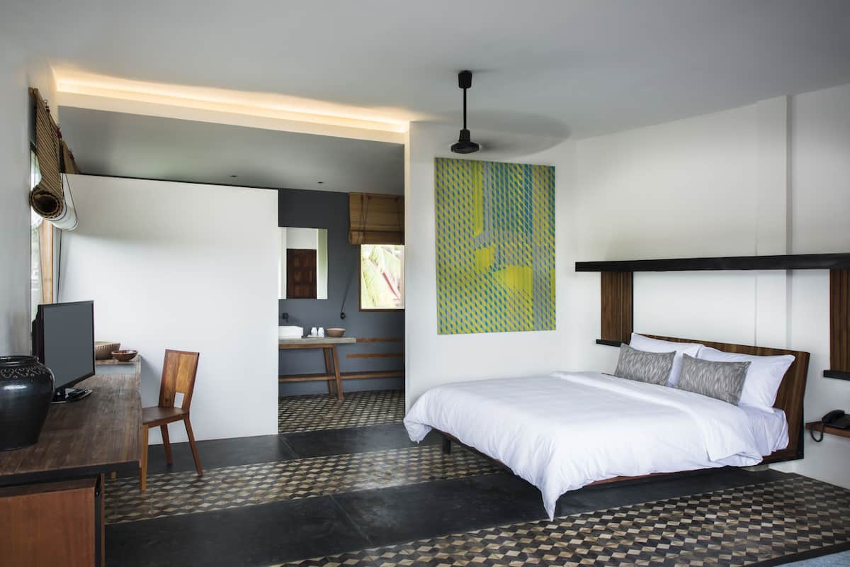 Ein modernes Schlafzimmer mit einem großen Bett, einem Schreibtisch und einem Stuhl.