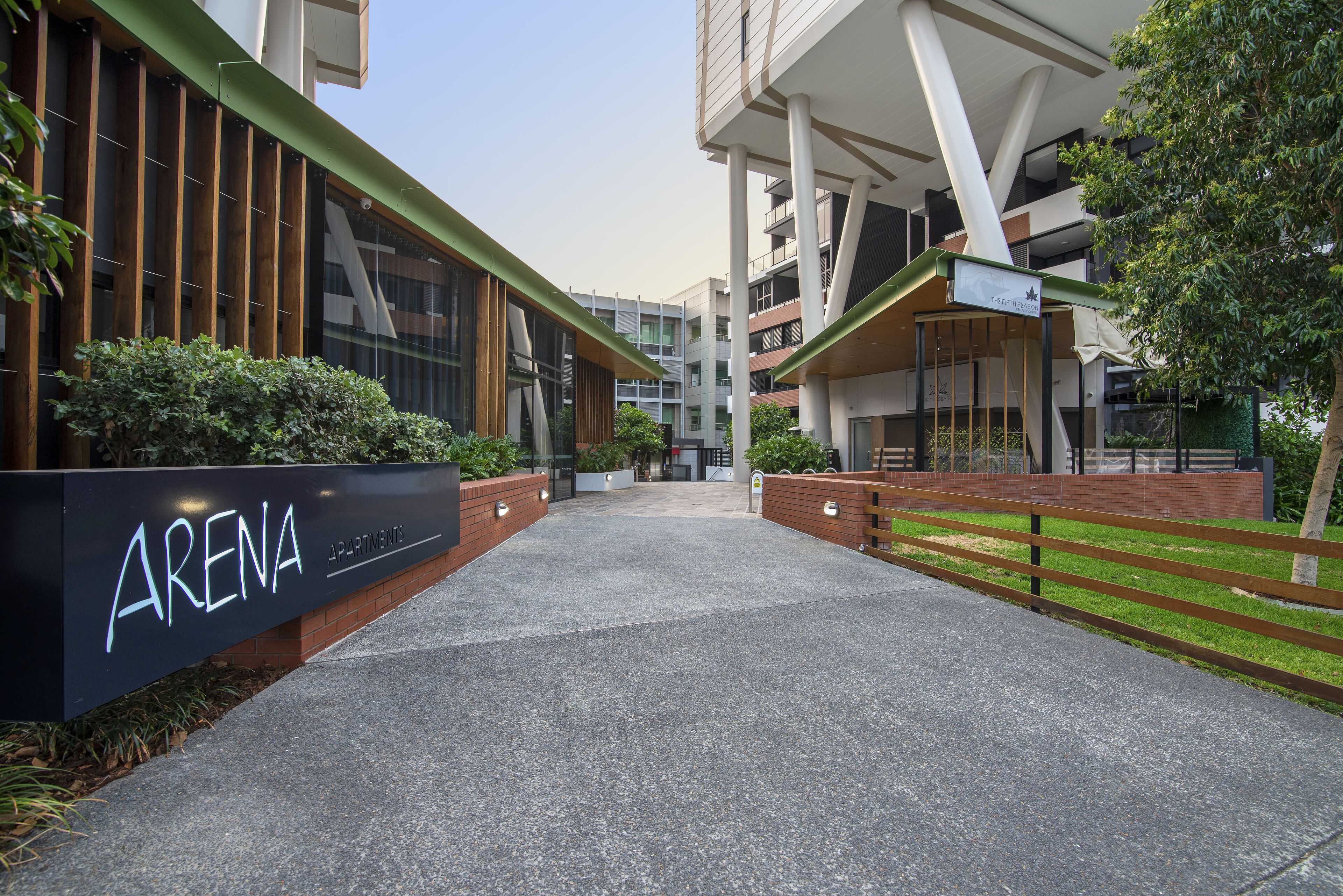 A modern building entrance with a sign reading "ARENA APARTMENTS".
