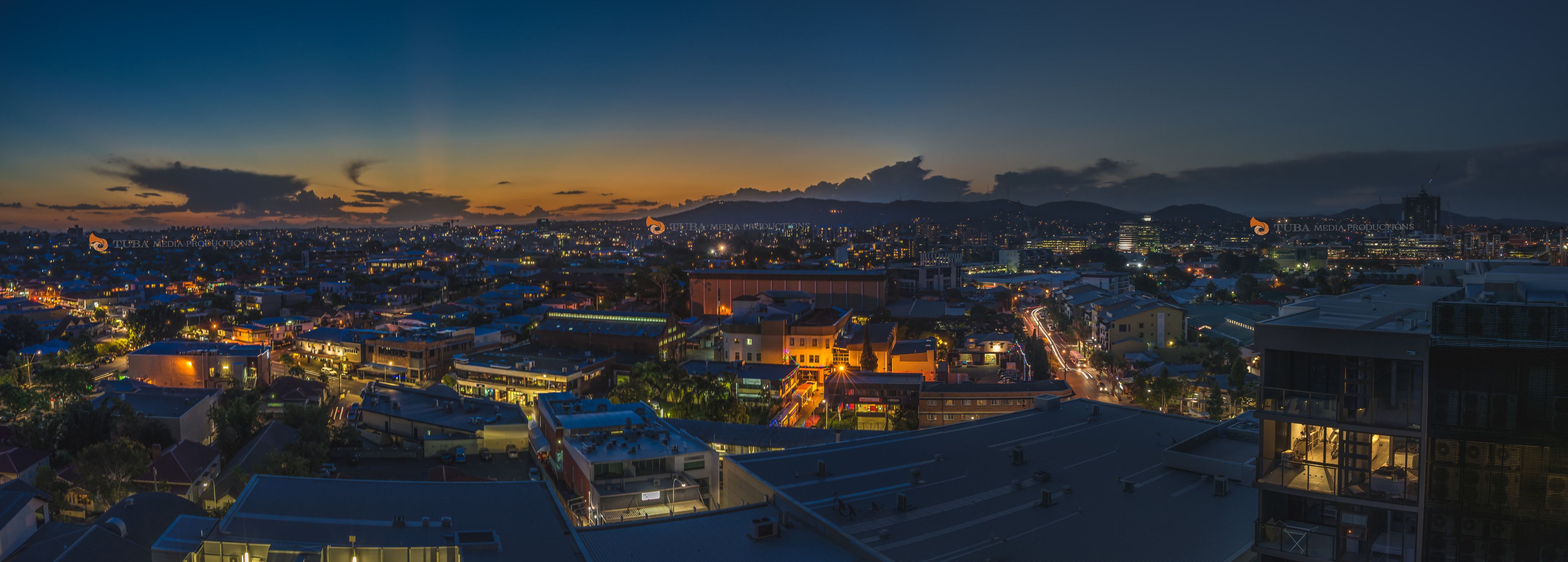 Un paisaje urbano al anochecer con edificios iluminados y cielo despejado.