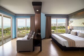 Enjoy a city view from the balcony, relax in the seating area with a sofa and flat-screen TV, and rest in the comfortable bed with striped bedding.