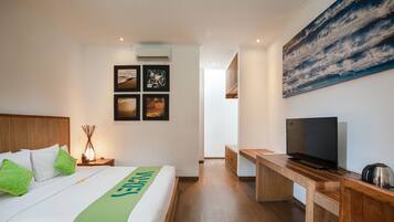 Habitación de hotel con una cama, un escritorio, un televisor y un cuadro grande en la pared.