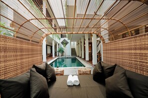 A pool area with lounge chairs and a view of the pool. - Sedasa Lodge (Tibubeneng)