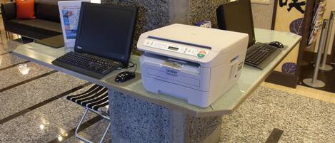 A desk with a laptop, a Brother printer, and a keyboard.