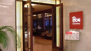 L’entrée d’un hôtel, avec une enseigne indiquant « BON, restaurant décontracté ».