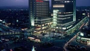 Un complexe hôtelier moderne composé de plusieurs immeubles de grande hauteur, reliés par des passerelles, et situé dans une rue animée de la ville.