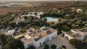 Una extensa propiedad con varias construcciones, piscina y abundante vegetación.