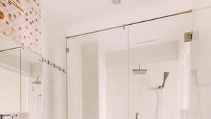 A modern bathroom with a glass-enclosed shower, a white toilet, and a wooden vanity with a large mirror. - Dragon Sea Hotel (Da Nang)