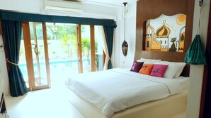 Ein Schlafzimmer mit einem großen Bett, Blick auf einen Pool und einem Wandgemälde.