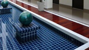 A modern hotel interior with a central water feature, multiple floors, and a clean, minimalist design.