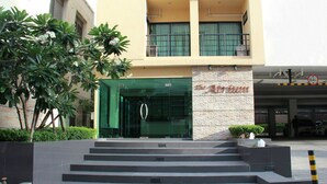 A hotel entrance with a staircase leading up to a glass door.