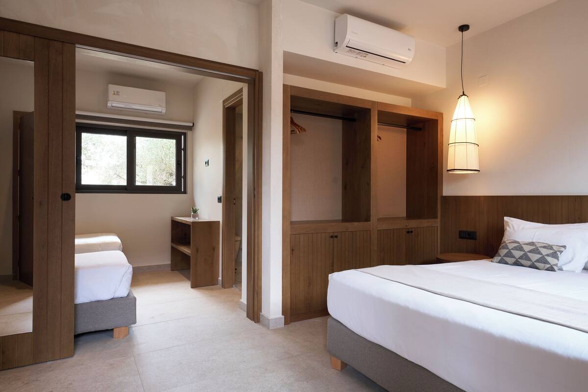 Een slaapkamer met een bed, een kledingkast, een nachtkastje en een raam.