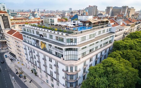 A multi-story hotel with a rooftop pool and terrace.