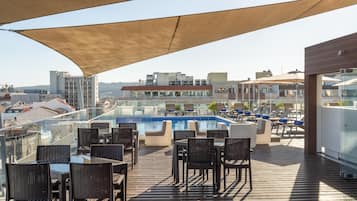 Área de piscina no terraço, com espreguiçadeiras e piscina.