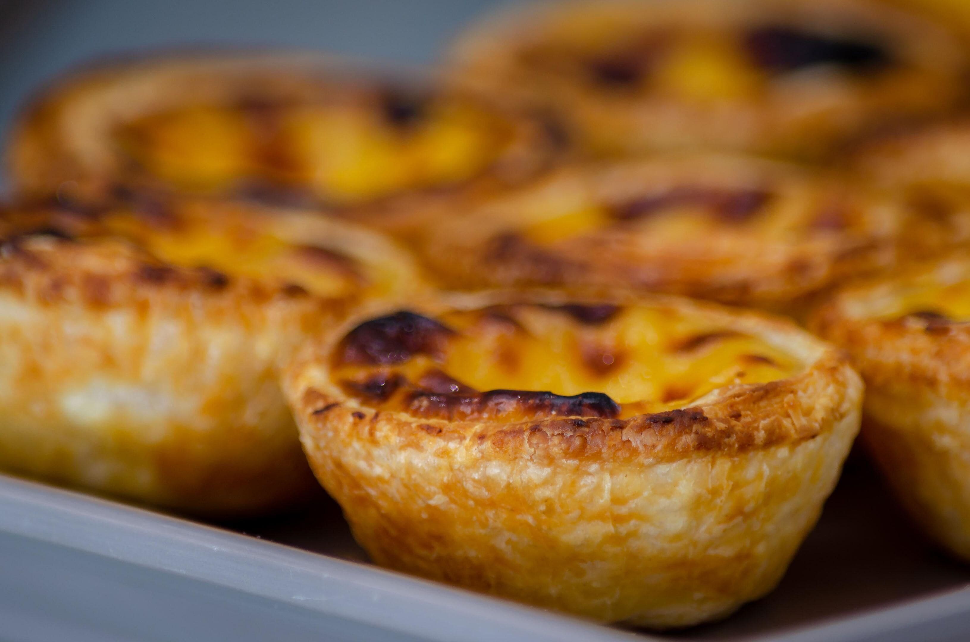 A tray of Portuguese egg tarts with a golden-brown crust.