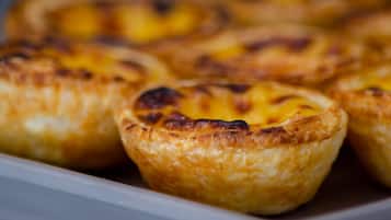 Una bandeja de pasteles portugueses de crema pastelera con una costra dorada.